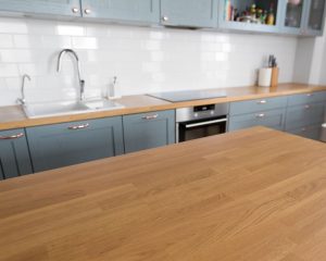 A kitchen with blue cabinets and a wooden counter top installed by Kitchen Fitters in Basingstoke.