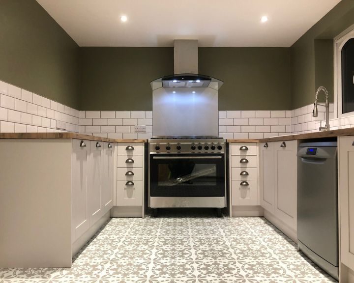 A new kitchen installation featuring new integrated appliances including a dishwasher and cooker with hob and extractor fan.