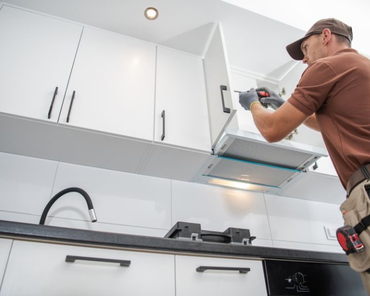 A basingstoke kitchen fitter installing a kitchen cupboard as as part of a new kitchen installation.